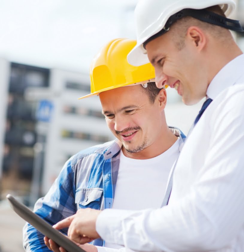 Gestionnaire en construction qui présente les plans de croissance sur mobile à un employé